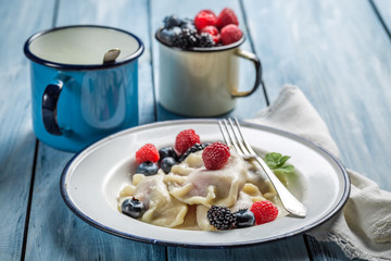 Homemade dumplings with fresh fruits and cream