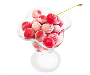 frozen cherries in the cup of glass on a white background