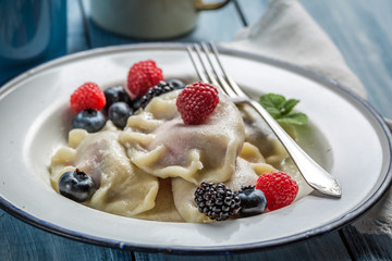Homemade dumplings with fruits and cream