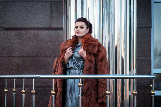 fashion outdoor photo of sexy glamour woman with dark hair wearing luxurious fur coat