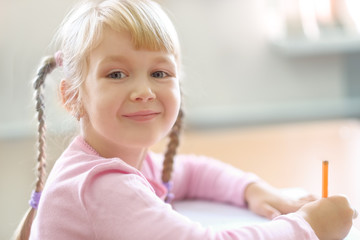 Cute five years old  blonde girl sitting at classroom