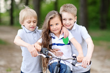 three children playing on meadow in summer