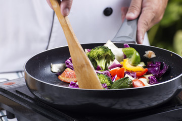 Chef cooking stir fried vegetable