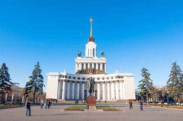 Moscow, Russia-November 06: The central pavilion of VDNKh with Vladimir Lenin monument on the foreground on November 06,2015 in Moscow, people go sightseeing.