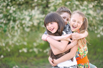 three children playing on meadow in summer