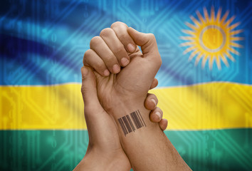 Barcode ID number on wrist of dark skinned person and national flag on background - Rwanda