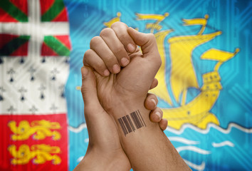 Obraz na płótnie Canvas Barcode ID number on wrist of dark skinned person and national flag on background - Saint Pierre and Miquelon