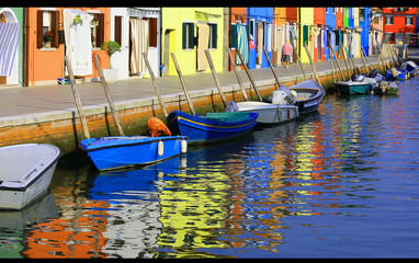 Colourfully houses on Burano and reflection on the water