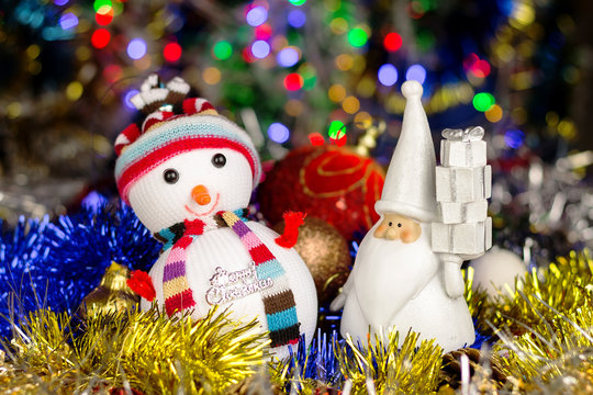 Christmas decoration, Snowman, Santa, balls, tinsel on blurred lights background