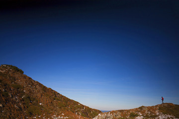 Silhouette of woman running along the ridge.