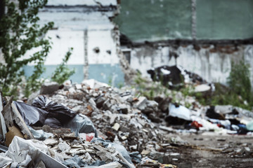 A closeup image of a garbage dump at ruined building background