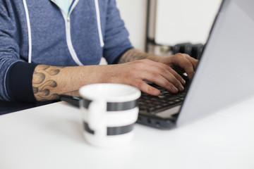 Young man drinking coffee and working