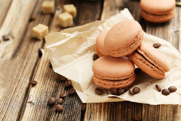 Coffee macarons with coffee beans on brown wooden background