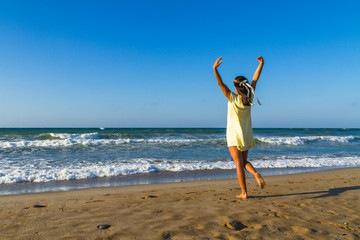 Young woman enjoys time on a  beach at dusk.