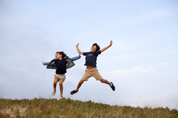 Fototapeta na wymiar Niño y niña saltando alegres