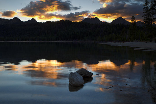 Two rocks in lake at sunset.