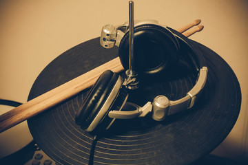 Headphone,drumstick on drum  blur background by vintage tone.