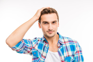 Obraz premium Handsome cheerful young man holding hand on his hair