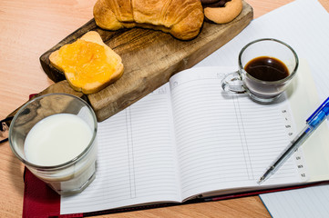 Agenda, quaderno, penna e colazione. Esprime concetti legati al lavoro © GMfoto