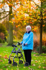 Naklejka na ściany i meble Senior lady with a walker in autumn park