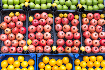 Pomegranates, apples and lemons for sale at a market