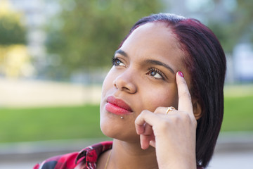 Portrait of young woman thinking, outdoor.