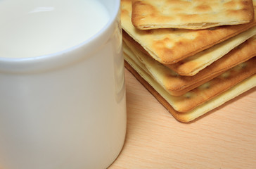Selective focus craker  and blur milk  on wood background.
