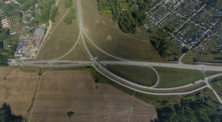 Aerial city view with crossroads, roads, houses, buildings, parks, parking lots, bridges