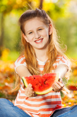 Portrait of girl with watermelon sitting in forest