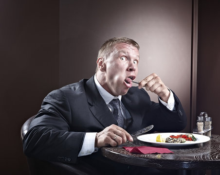 Muscular businessman eating