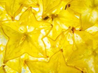 back lit yellow ripe slices of star fruit carambola