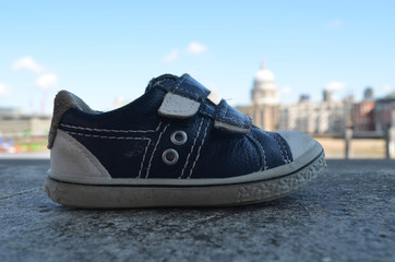 Naklejka premium Little abandoned children shoe on stone river dike, London