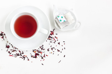 Fototapeta na wymiar Cup of tea with dried flowers around it, white background, top view.