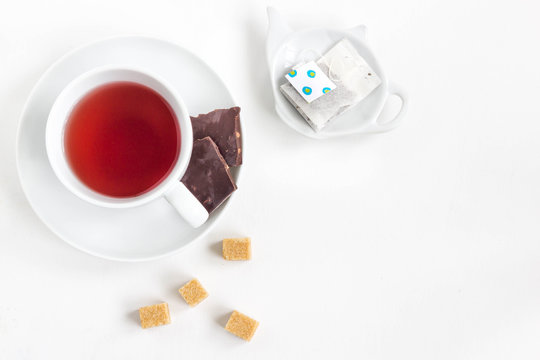 Fruit Tea In White Cup With Chocolate And Cube Sugar. White Background, Top View.