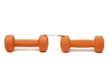 Two dumbbells and a cigarette on a white background isolated