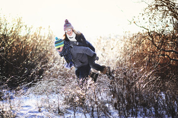 boy and girl in warm clothes on a background of trees