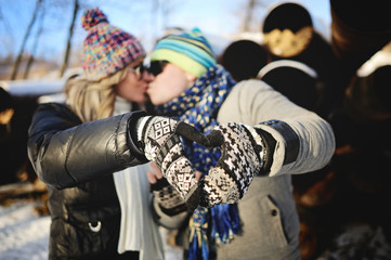 Fototapeta na wymiar boy and girl kissing on the background of a winter background