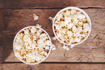 Popcorn in paper cups on wooden surface. Top view