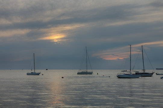 Fototapeta Sailboats on open sea in a summer at sunset time