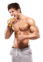 Strong Athletic Man  showing muscular body and eating a banana