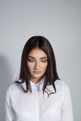 Fototapeta premium Young beautiful woman with closed eyes over white background. Co