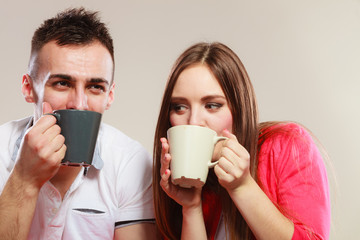 young couple holds mugs with tea or coffee