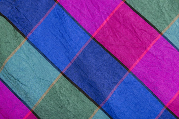 Fototapeta premium Green, green and magenta plaid print as background. Colored square pattern. Checked fabric. Tartan pattern.