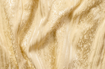 Yellow gold textile pattern as a background. Close up on crumpled sparkly gold material texture...