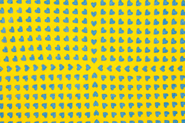 Hearts pattern on yellow fabric. Blue hearts print as background.