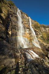 Obraz premium Beautiful waterfall in the forest with rainbow