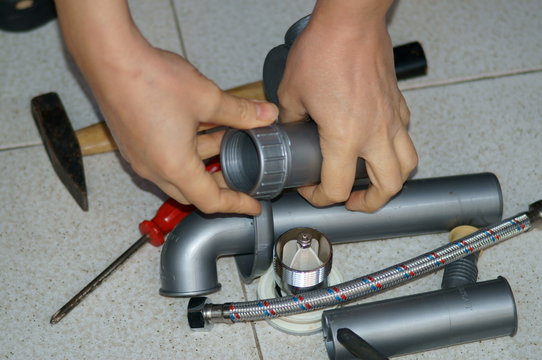 Mani di un idraulico al lavoro