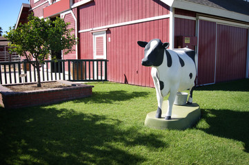 replica cow on farm with barn