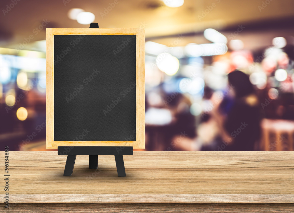 Poster blackboard menu with easel on wooden table with blur restaurant