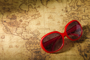 Red sun glasses on old map